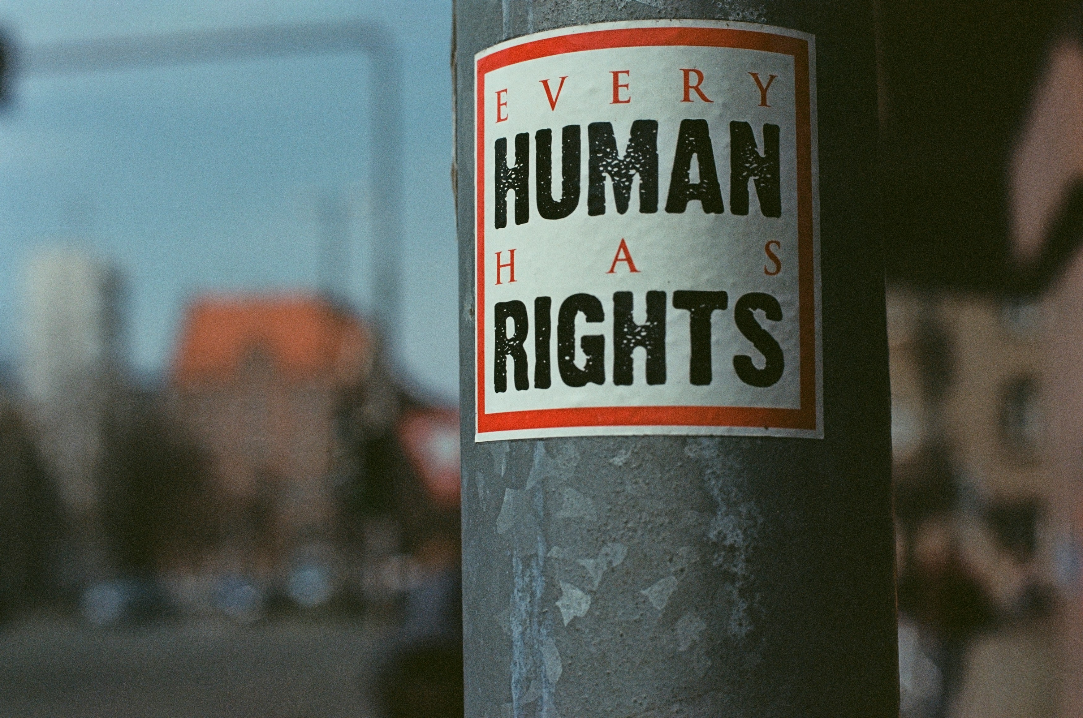 A foto van een sticker op een paal dat in engels zegt "Elke mens heeft rechten"